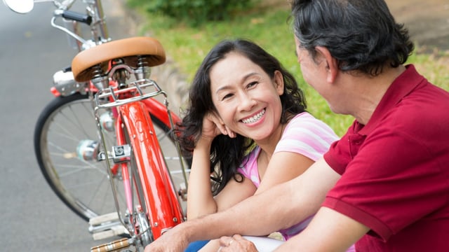 Couple souriant avec un vélo