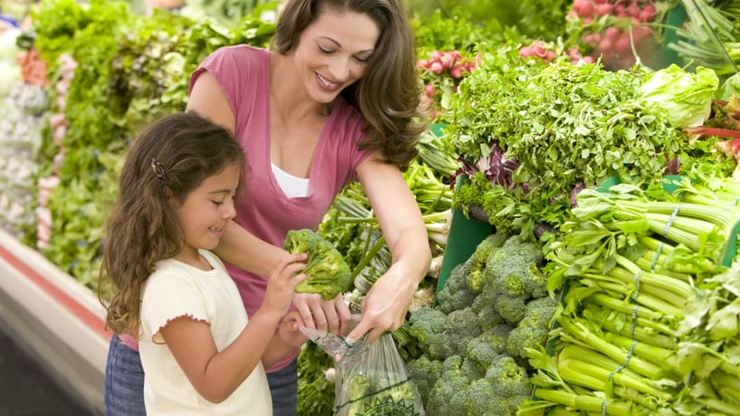 madre e hija en el supermercado comprando verduras