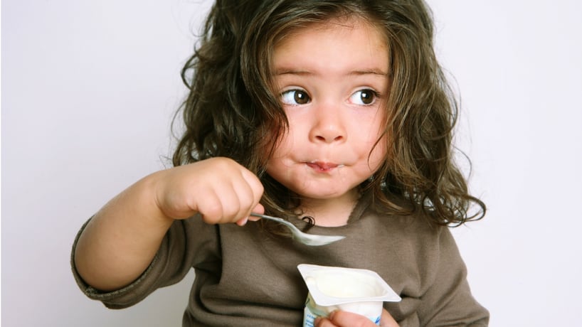niña pequeña tomando yogur
