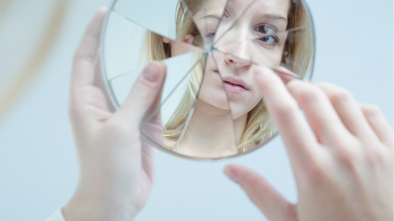 reflejo de mujer en espejo roto