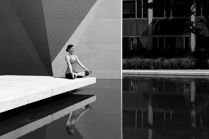 mujer meditando en un estanque, imagen en blanco y negro