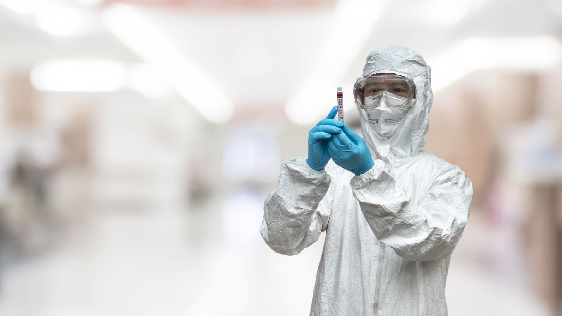 hombre con traje especial analizando prueba de coronavirus