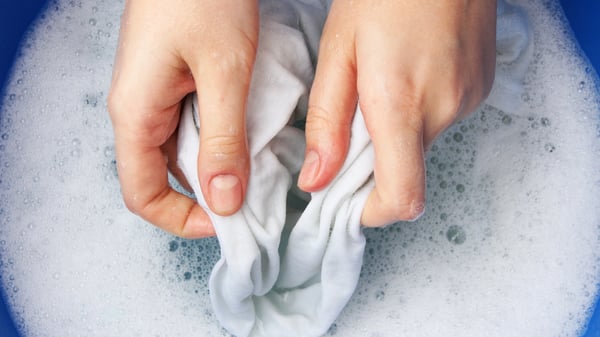 manos lavando ropa